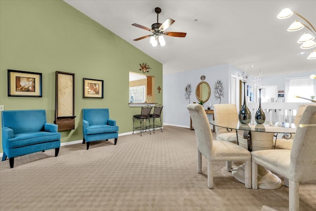 carpeted dining room featuring high vaulted ceiling, ceiling fan, and baseboards