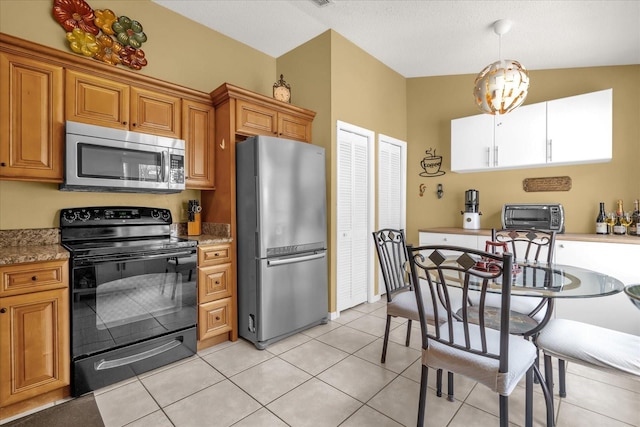 kitchen featuring hanging light fixtures, brown cabinetry, light tile patterned floors, a toaster, and appliances with stainless steel finishes