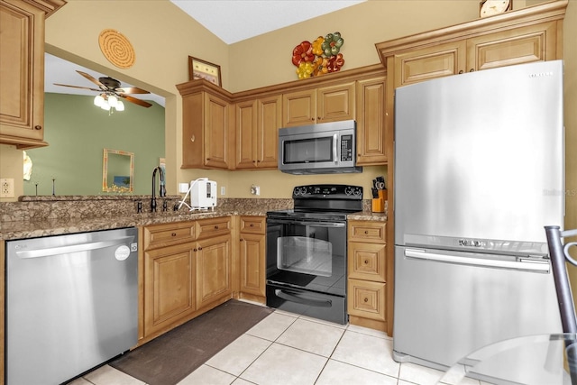 kitchen with a ceiling fan, a sink, light tile patterned floors, stone countertops, and appliances with stainless steel finishes