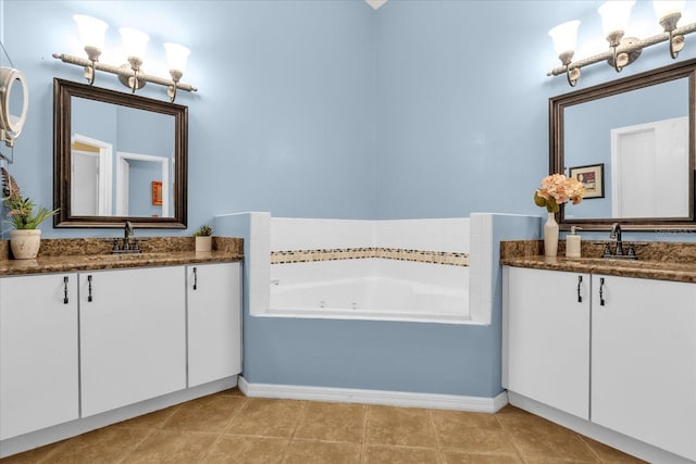 bathroom with two vanities, a tub with jets, and a sink