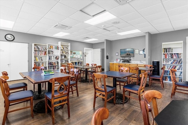 dining area with a paneled ceiling, visible vents, and dark wood-style flooring