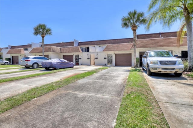 multi unit property featuring an attached garage and driveway