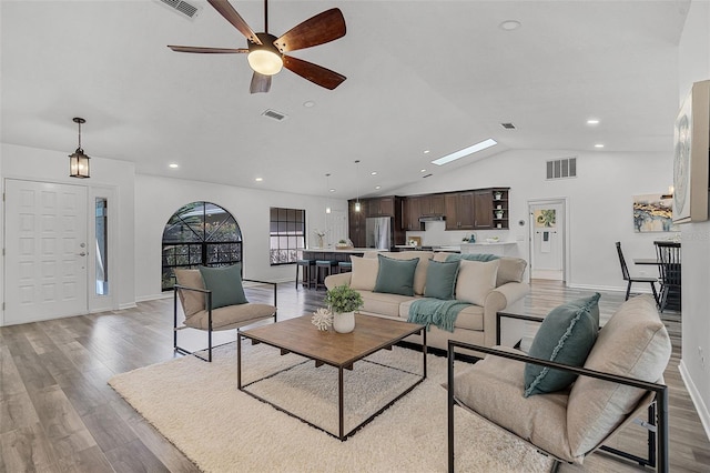 living area featuring ceiling fan, lofted ceiling, and visible vents