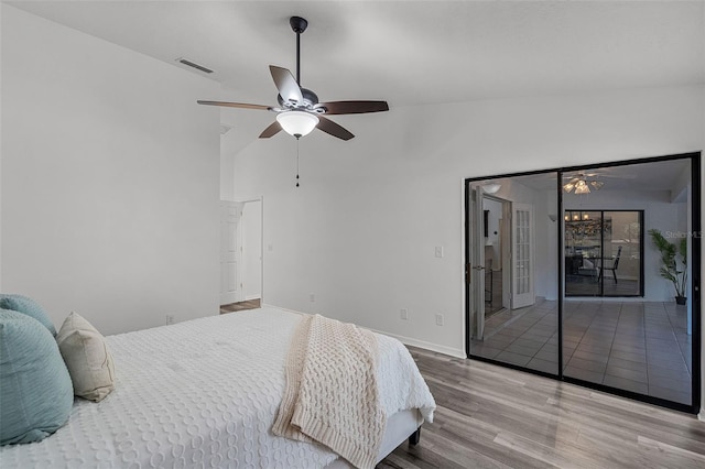 bedroom featuring baseboards, visible vents, wood finished floors, access to outside, and ceiling fan