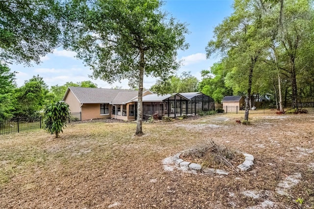 view of yard with a fenced backyard and glass enclosure