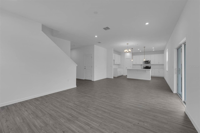 unfurnished living room featuring dark wood-type flooring, visible vents, and recessed lighting