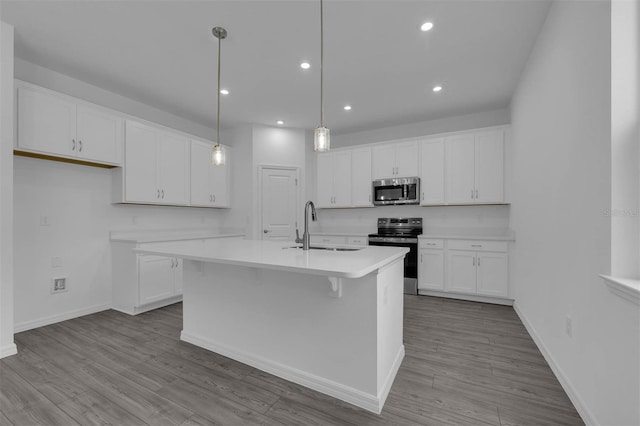 kitchen with white cabinets, stainless steel appliances, light countertops, and a sink