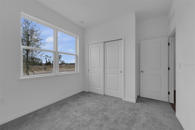 unfurnished bedroom with baseboards, a closet, and carpet