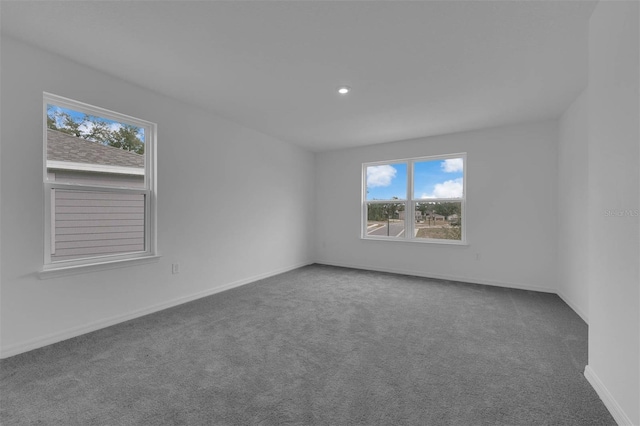 carpeted empty room with baseboards, a wealth of natural light, and recessed lighting