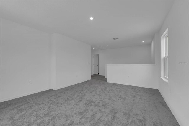 carpeted spare room featuring attic access, baseboards, visible vents, and recessed lighting