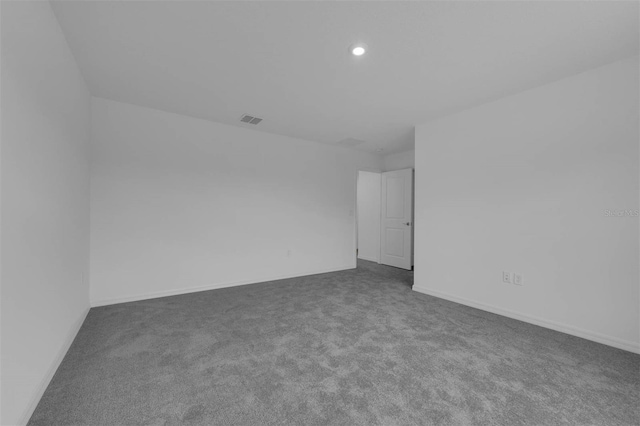 spare room with baseboards, visible vents, dark carpet, and recessed lighting