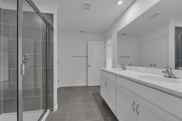 bathroom with tile patterned floors, visible vents, a sink, and a stall shower