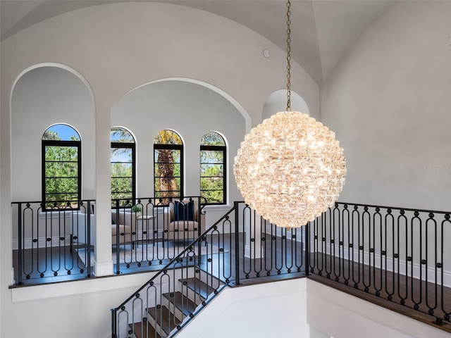 interior space with arched walkways, an inviting chandelier, vaulted ceiling, and plenty of natural light