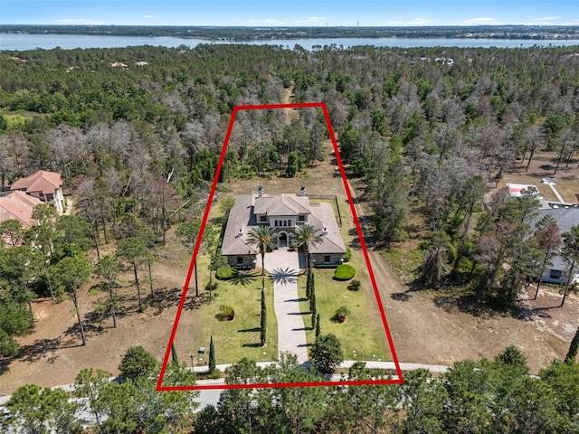 birds eye view of property with a forest view and a water view