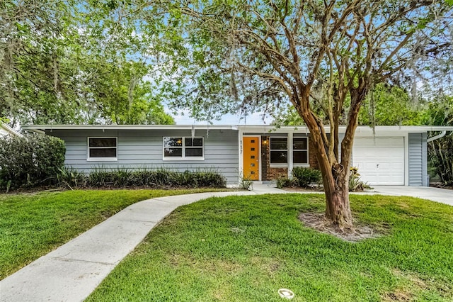 single story home featuring an attached garage, driveway, and a front lawn