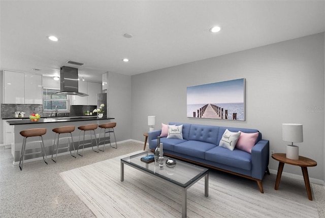 living room featuring light speckled floor, baseboards, and recessed lighting