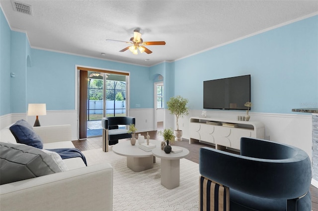 living area featuring arched walkways, wainscoting, and visible vents