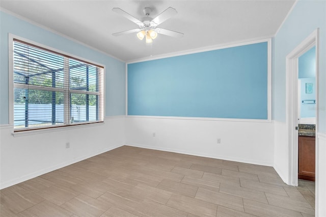 spare room with crown molding and a ceiling fan