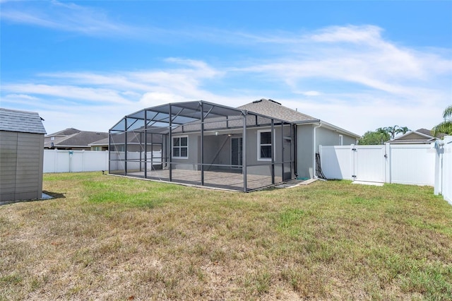 rear view of house with a fenced backyard, a gate, a lawn, and a patio area