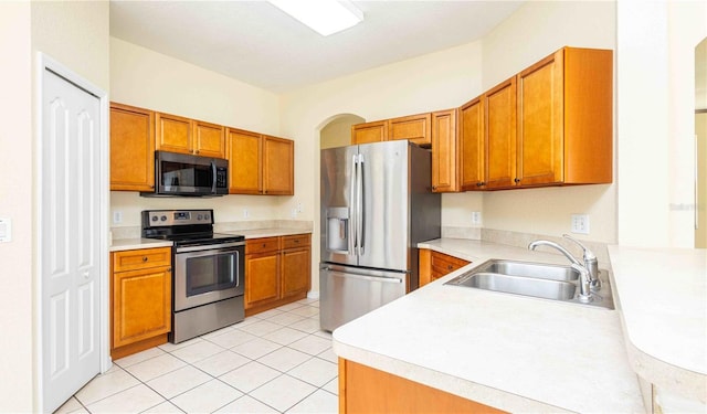 1204 Blackheath Ct, Davenport, FL 33897 - kitchen featuring appliances with stainless steel finishes, light countertops, brown cabinetry, and light tile patterned floors