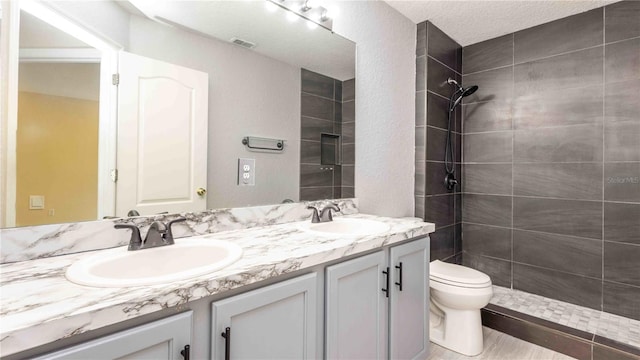 1204 Blackheath Ct, Davenport, FL 33897 - full bathroom with double vanity, a tile shower, and a textured ceiling