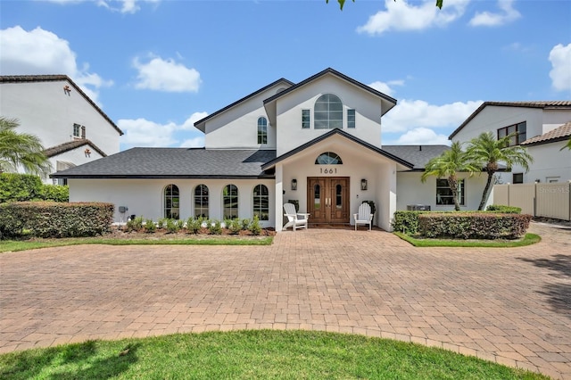 1661 Woodland Ave, Winter Park, FL 32789 - view of front facade with fence, french doors, and stucco siding