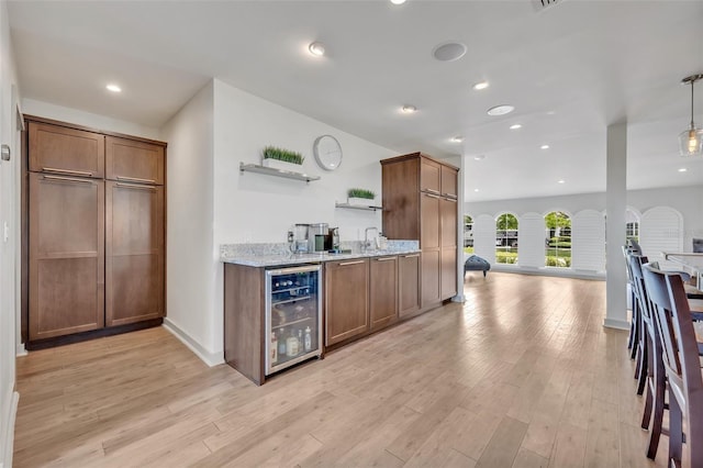 1661 Woodland Ave, Winter Park, FL 32789 - bar with beverage cooler, light wood finished floors, decorative light fixtures, and indoor wet bar