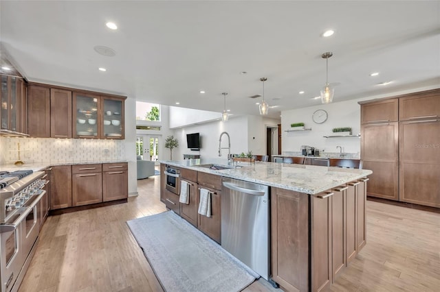 1661 Woodland Ave, Winter Park, FL 32789 - kitchen with a sink, appliances with stainless steel finishes, a kitchen island with sink, and light wood-style flooring