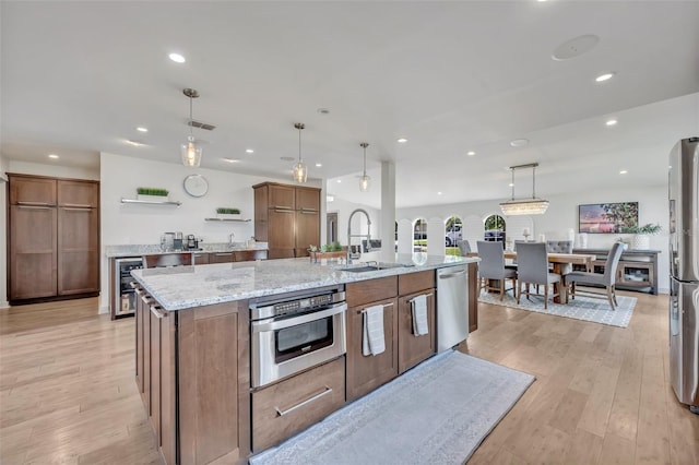 1661 Woodland Ave, Winter Park, FL 32789 - kitchen with brown cabinetry, appliances with stainless steel finishes, open shelves, a sink, and recessed lighting
