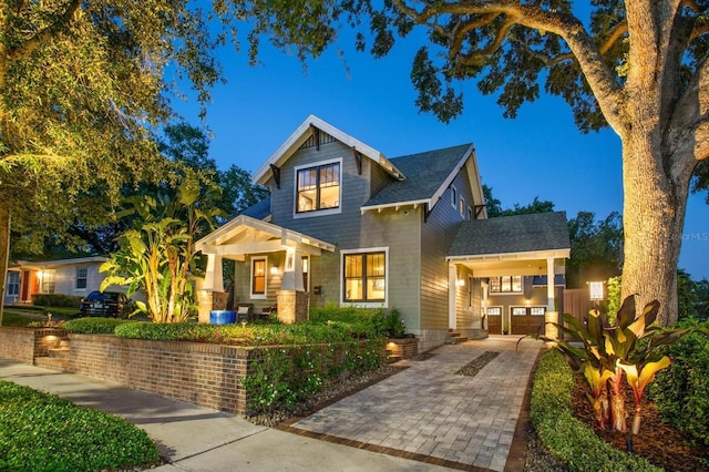 view of front of home with roof with shingles and a porch