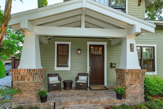 view of exterior entry featuring covered porch