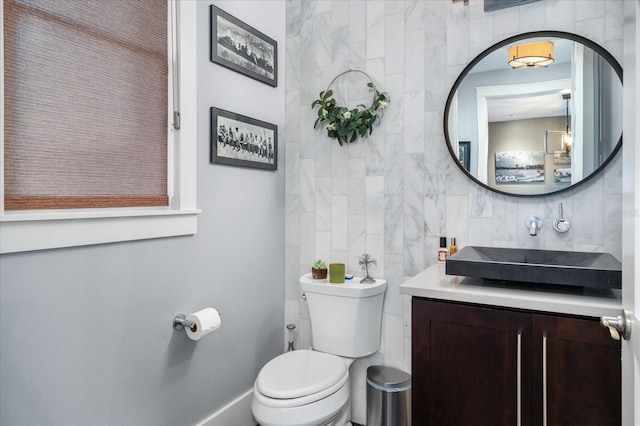 bathroom with vanity, tile walls, baseboards, backsplash, and toilet