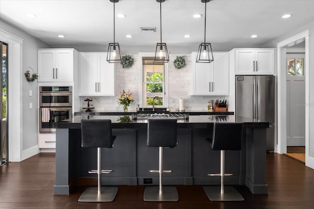 kitchen featuring dark countertops, a wealth of natural light, and appliances with stainless steel finishes