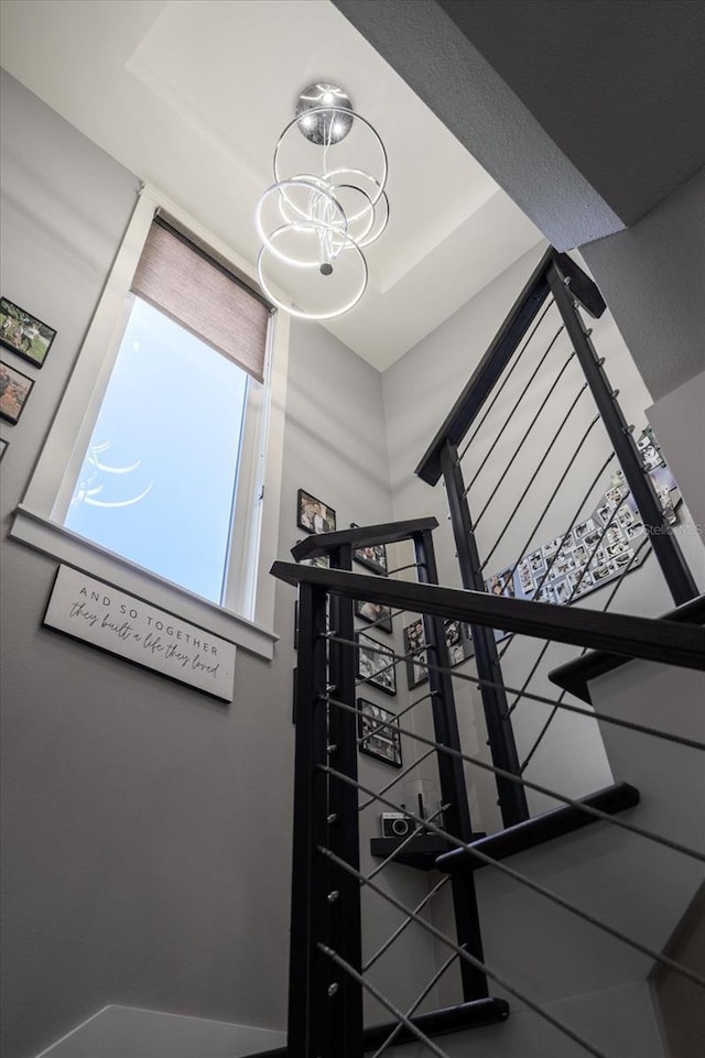 staircase featuring an inviting chandelier