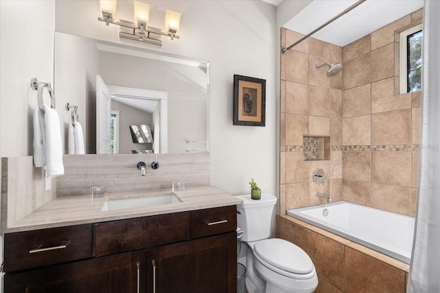 full bathroom with vanity, tiled shower / bath, and toilet
