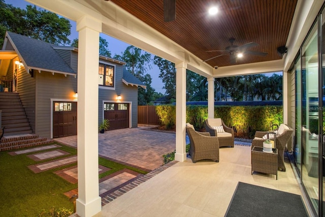 view of patio featuring stairway, driveway, a ceiling fan, an attached garage, and fence