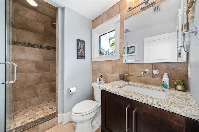 bathroom featuring vanity, toilet, a stall shower, and visible vents