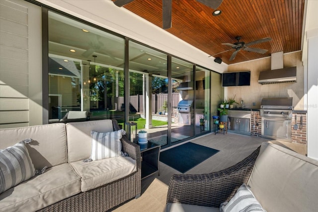 view of patio with outdoor lounge area, grilling area, fence, exterior kitchen, and ceiling fan