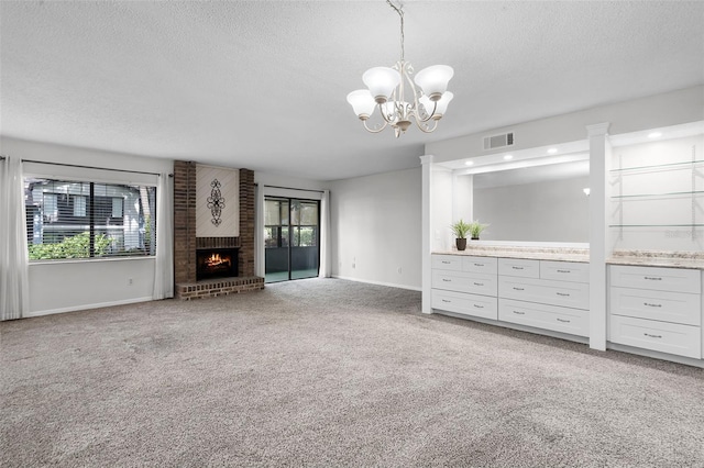 11 Escondido Cir Unit 110, Altamonte Springs, FL 32701 - unfurnished living room featuring a textured ceiling, plenty of natural light, carpet floors, a chandelier, and a fireplace