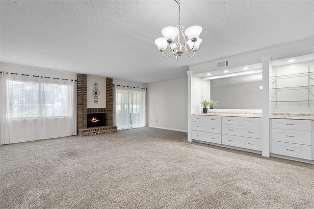 11 Escondido Cir Unit 110, Altamonte Springs, FL 32701 - unfurnished living room with a textured ceiling, a chandelier, carpet floors, and a brick fireplace