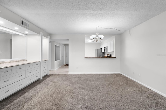 11 Escondido Cir Unit 110, Altamonte Springs, FL 32701 - unfurnished living room featuring carpet flooring, a chandelier, a textured ceiling, and recessed lighting