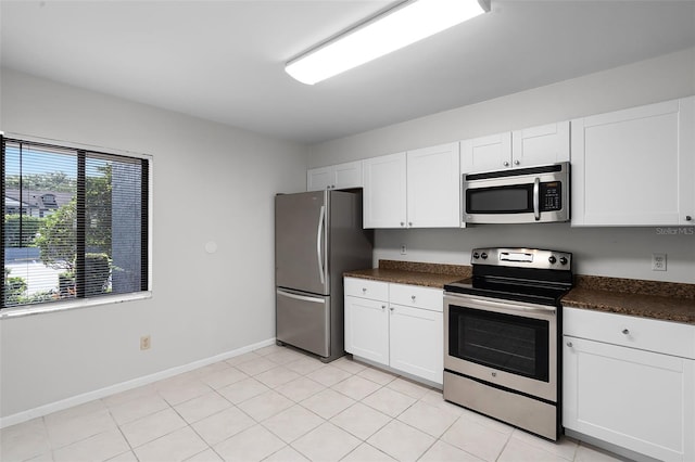 11 Escondido Cir Unit 110, Altamonte Springs, FL 32701 - kitchen with stainless steel appliances, dark countertops, white cabinetry, and light tile patterned flooring