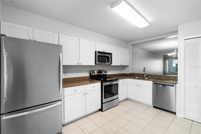 11 Escondido Cir Unit 110, Altamonte Springs, FL 32701 - kitchen with stainless steel appliances, white cabinets, dark countertops, and a chandelier