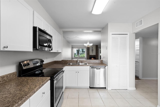 11 Escondido Cir Unit 110, Altamonte Springs, FL 32701 - kitchen featuring stainless steel appliances, dark countertops, white cabinetry, and light tile patterned flooring