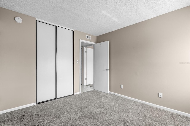 11 Escondido Cir Unit 110, Altamonte Springs, FL 32701 - unfurnished bedroom with a textured ceiling, carpet, and a closet