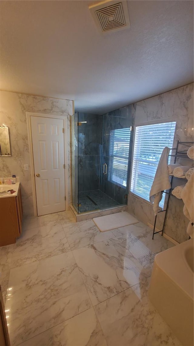 full bath featuring a shower stall, visible vents, marble finish floor, and vanity