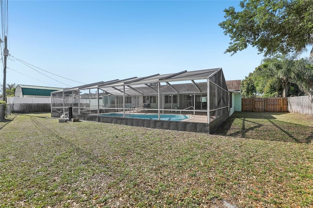 back of house with glass enclosure, a yard, a fenced in pool, and a fenced backyard