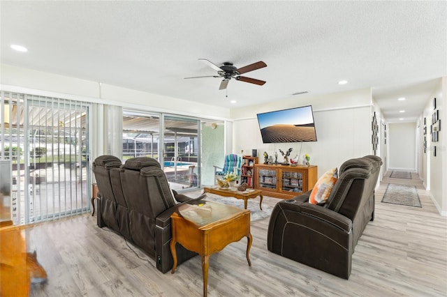 living room featuring a ceiling fan, recessed lighting, and light wood-style flooring