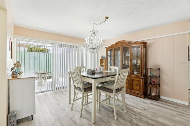 dining room featuring light wood-type flooring and a notable chandelier