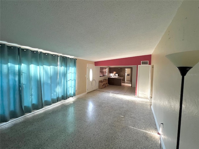 1221 Oak Haven Dr, Altamonte Springs, FL 32714 - unfurnished living room featuring visible vents, vaulted ceiling, baseboards, and a textured ceiling